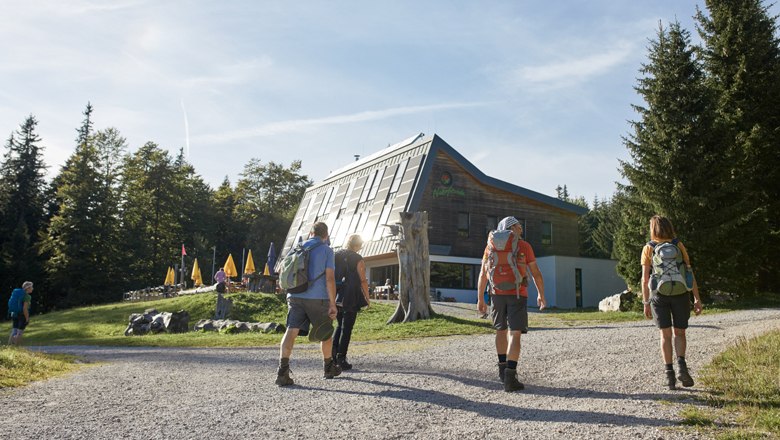 Eine Gruppe Wanderer kehren in die Hütte Knofeleben ein 